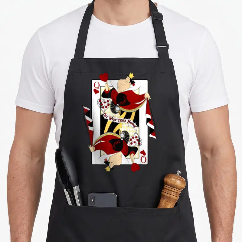 Alice queen apron - Queen of Hearts playing card design with Off With Their Heads text in red black white and yellow — shown on a black cotton canvas apron against a white background