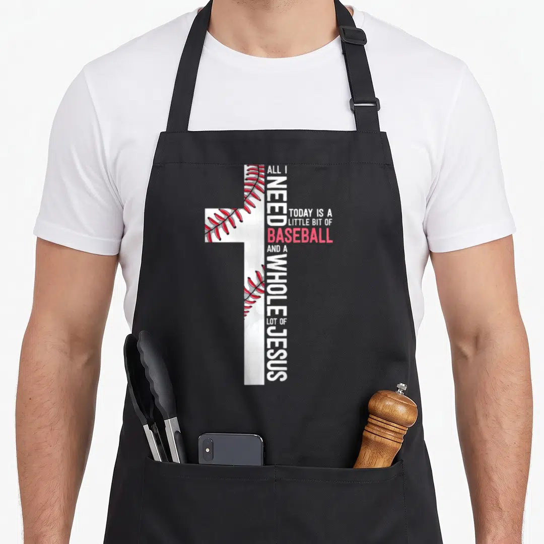 Baseball jesus christian apron - White cross with red stitching and vertical text reading ALL I NEED TODAY IS A LITTLE — shown on a black cotton canvas apron against a white background