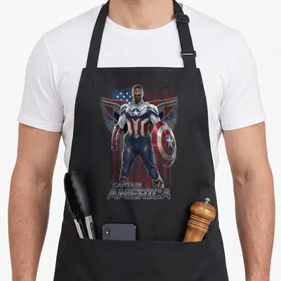 Soldier winter apron - Photo of Captain America holding shield in front of distressed flag with text CAPTAIN AMERICA — shown on a black cotton canvas apron against a white background