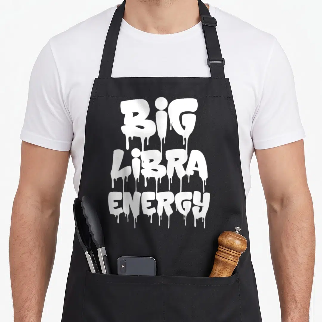 Libra energy birthday apron - White dripping text reading BIG LIBRA ENERGY stacked in three lines on a black background — shown on a black cotton canvas apron against a white background