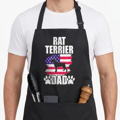 Rat american flag apron - Rat Terrier Dad text above distressed flag with dog silhouette and two paw prints — shown on a black cotton canvas apron against a white background