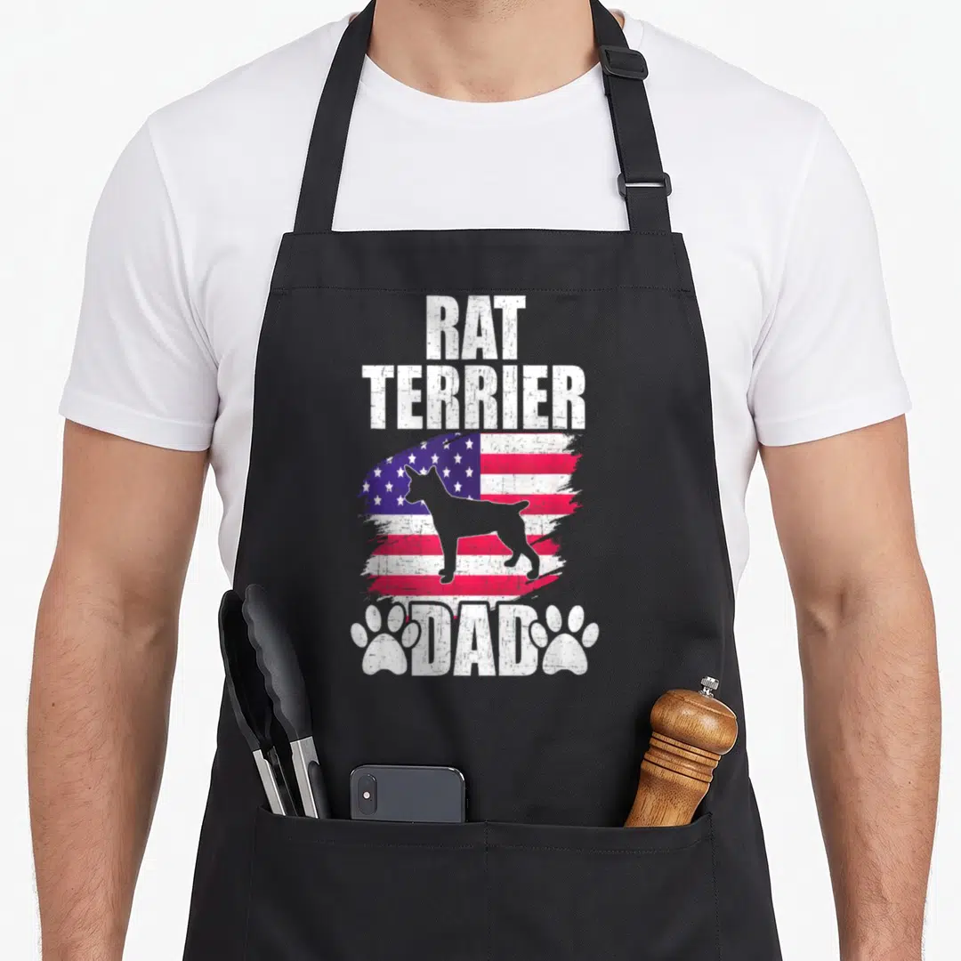 Rat american flag apron - Rat Terrier Dad text above distressed flag with dog silhouette and two paw prints — shown on a black cotton canvas apron against a white background