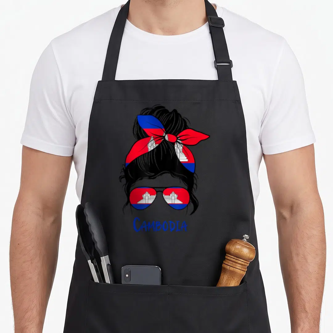 Cambodia cambodian girl apron - Cartoon woman with bun and sunglasses filled with Cambodian flag colors and temple icon — shown on a black cotton canvas apron against a white background
