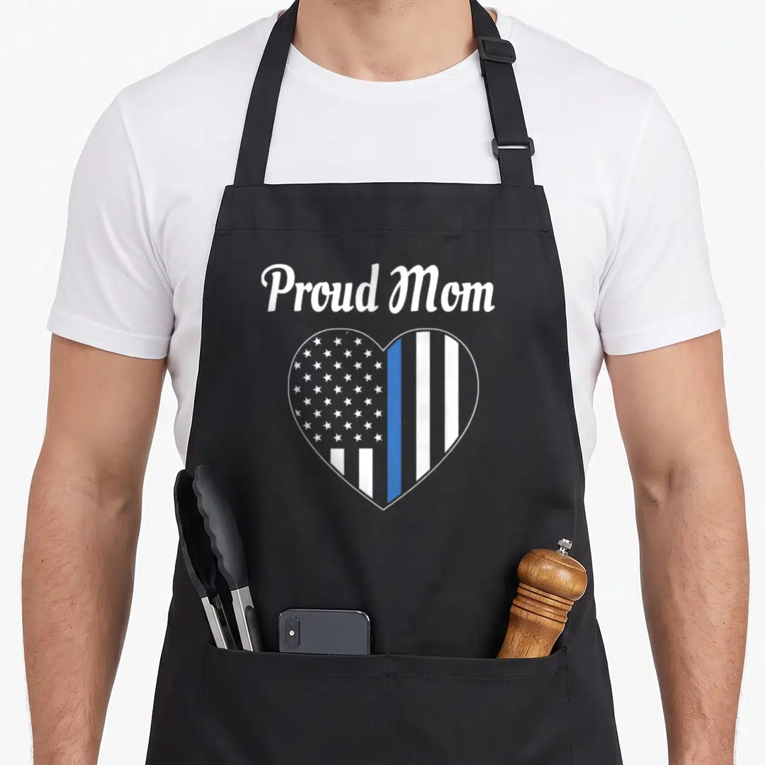 Law police apron - Proud Mom text above heart with thin blue line flag pattern in grey white and blue — shown on a black cotton canvas apron against a white background