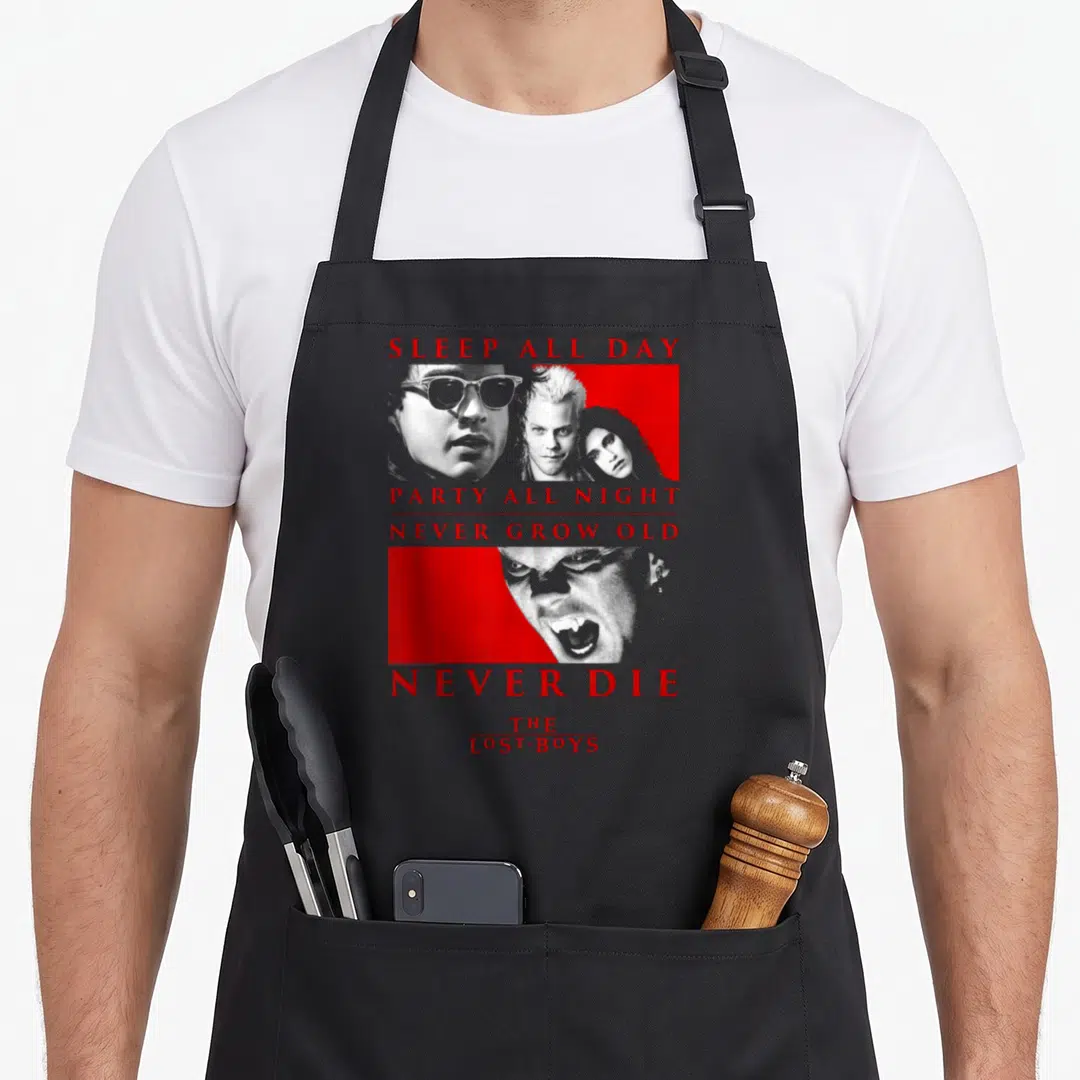 Lost halloween apron - Red text SLEEP ALL DAY PARTY ALL NIGHT stacked with grey vampire portraits on red panels — shown on a black cotton canvas apron against a white background