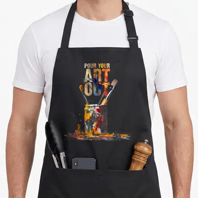Cat painter apron - Stacked text over paint jar with three brushes and orange blue red yellow white splashes — shown on a black cotton canvas apron against a white background