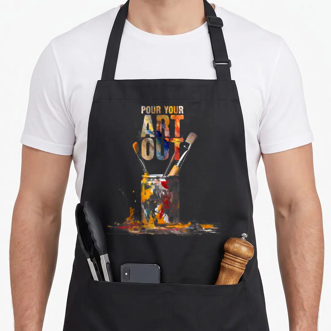 Cat painter apron - Stacked text over paint jar with three brushes and orange blue red yellow white splashes — shown on a black cotton canvas apron against a white background