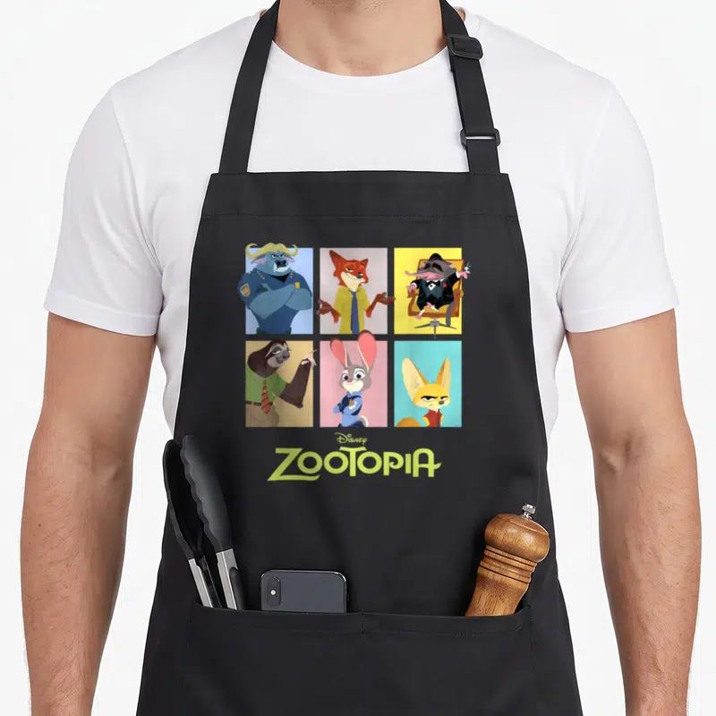 Funny grid character aprons - Six cartoon Zootopia characters in colored rectangles above centered Disney Zootopia logo — shown on a black cotton canvas apron against a white background