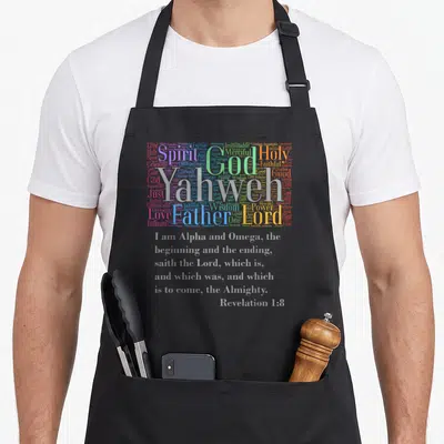Yahweh alpha apron - Multicolor word cloud of God attributes above grey Revelation 1:8 scripture text — shown on a black cotton canvas apron against a white background
