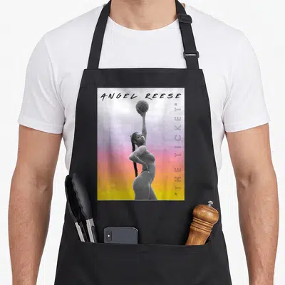 Funny reese angels in aprons - Angel Reese holding basketball against grey yellow orange purple gradient with vertical — shown on a black cotton canvas apron against a white background