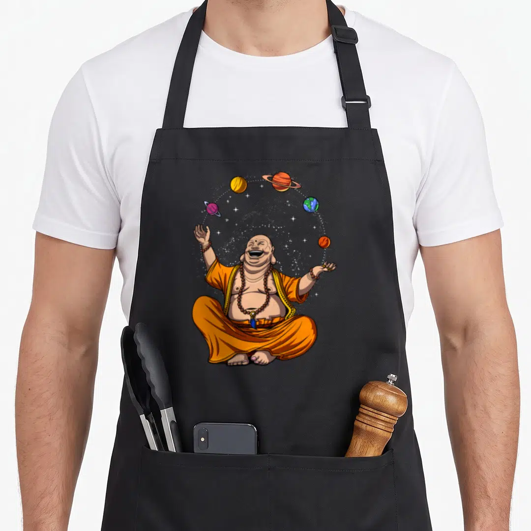 Space juggling apron - Laughing buddha in orange robes juggling five planets with white stars in cartoon style — shown on a black cotton canvas apron against a white background