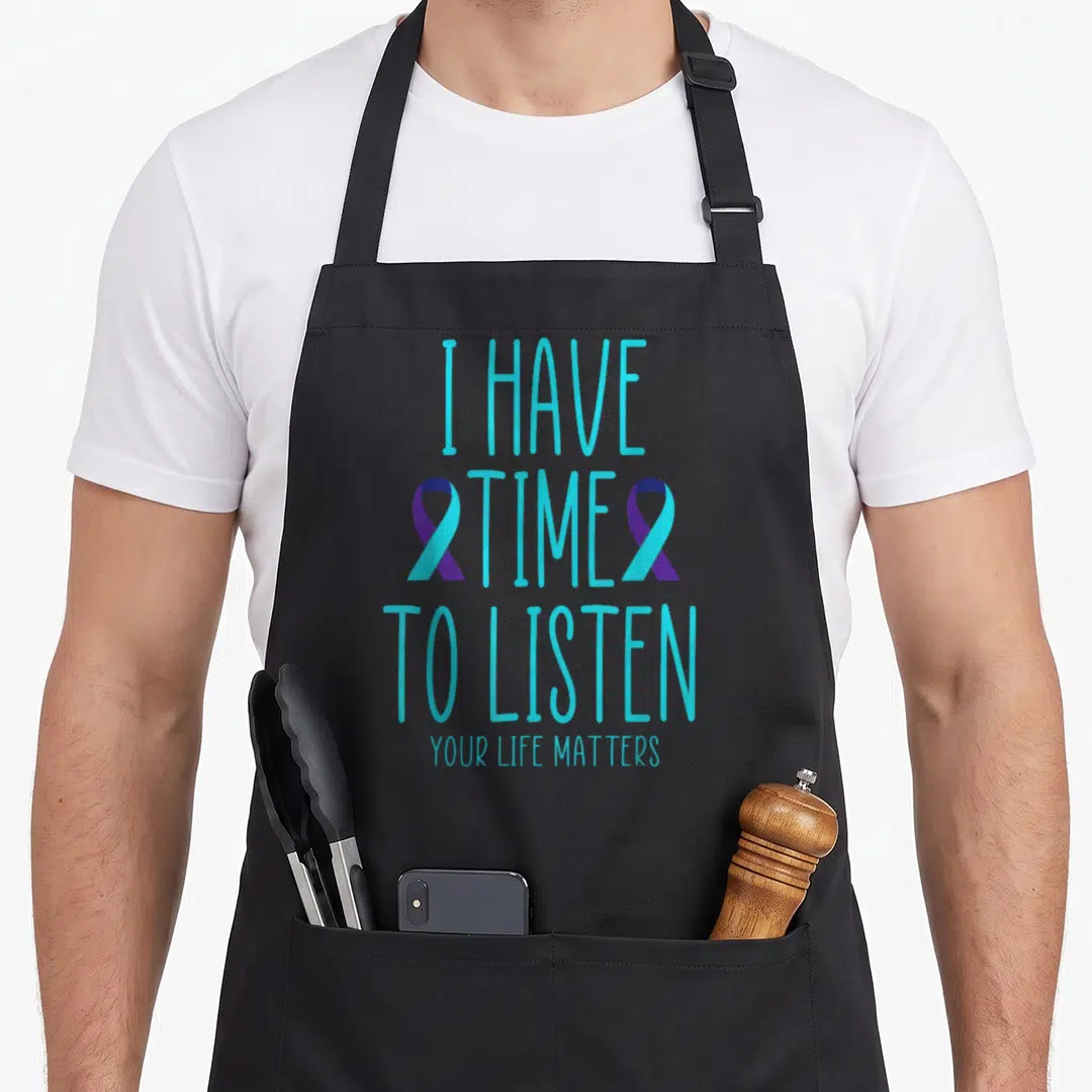 Listen rock quotes apron - Cyan text I Have Time To Listen flanked by two purple and cyan awareness ribbons — shown on a black cotton canvas apron against a white background
