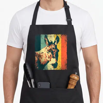 Donkey mule apron - Retro donkey head and shoulders centered over four vertical stripes in teal, cream, yellow — shown on a black cotton canvas apron against a white background