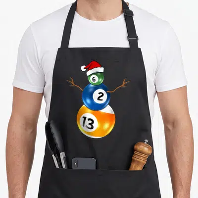 Billiard snowman apron - Cartoon snowman formed by stacked green 6, blue 2, and orange 13 billiard balls wearing — shown on a black cotton canvas apron against a white background