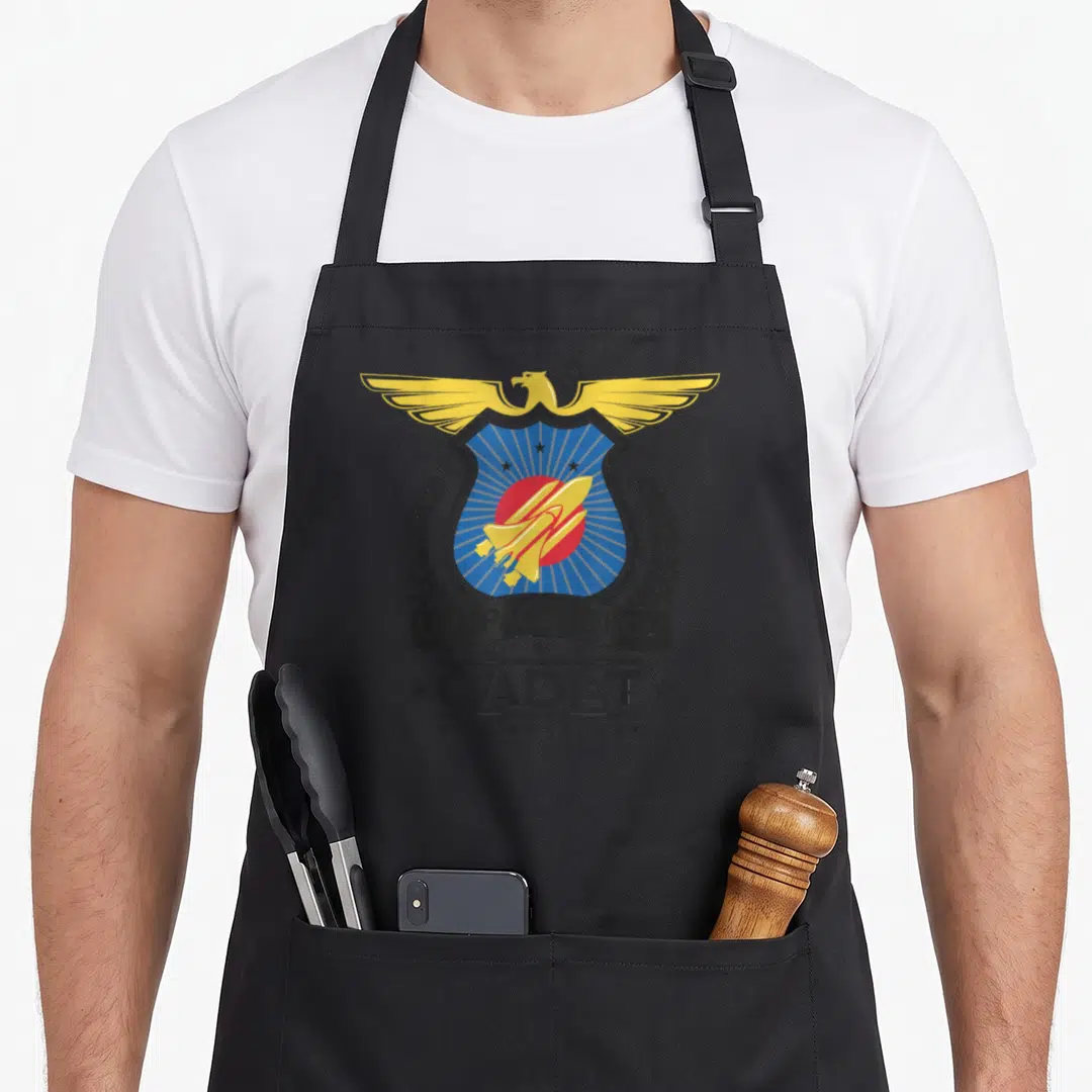 Cadet us aprons - Eagle blue shield shuttle emblem with US SPACE FORCE CADET text ribbon — shown on a black cotton canvas apron against a white background