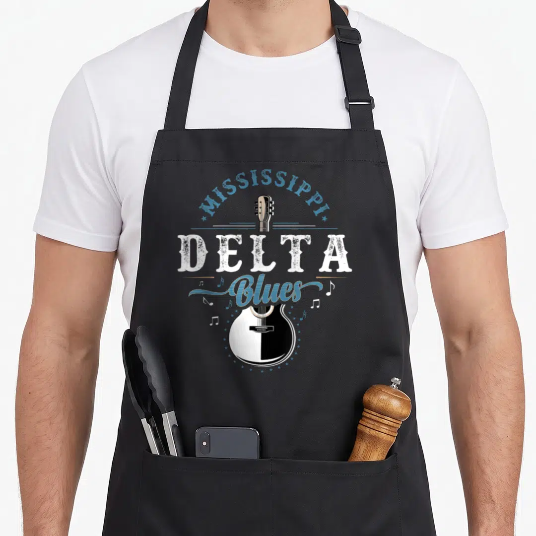 Blue mississippi girl apron - Vertical split guitar with Mississippi Delta Blues text and scattered stars — shown on a black cotton canvas apron against a white background