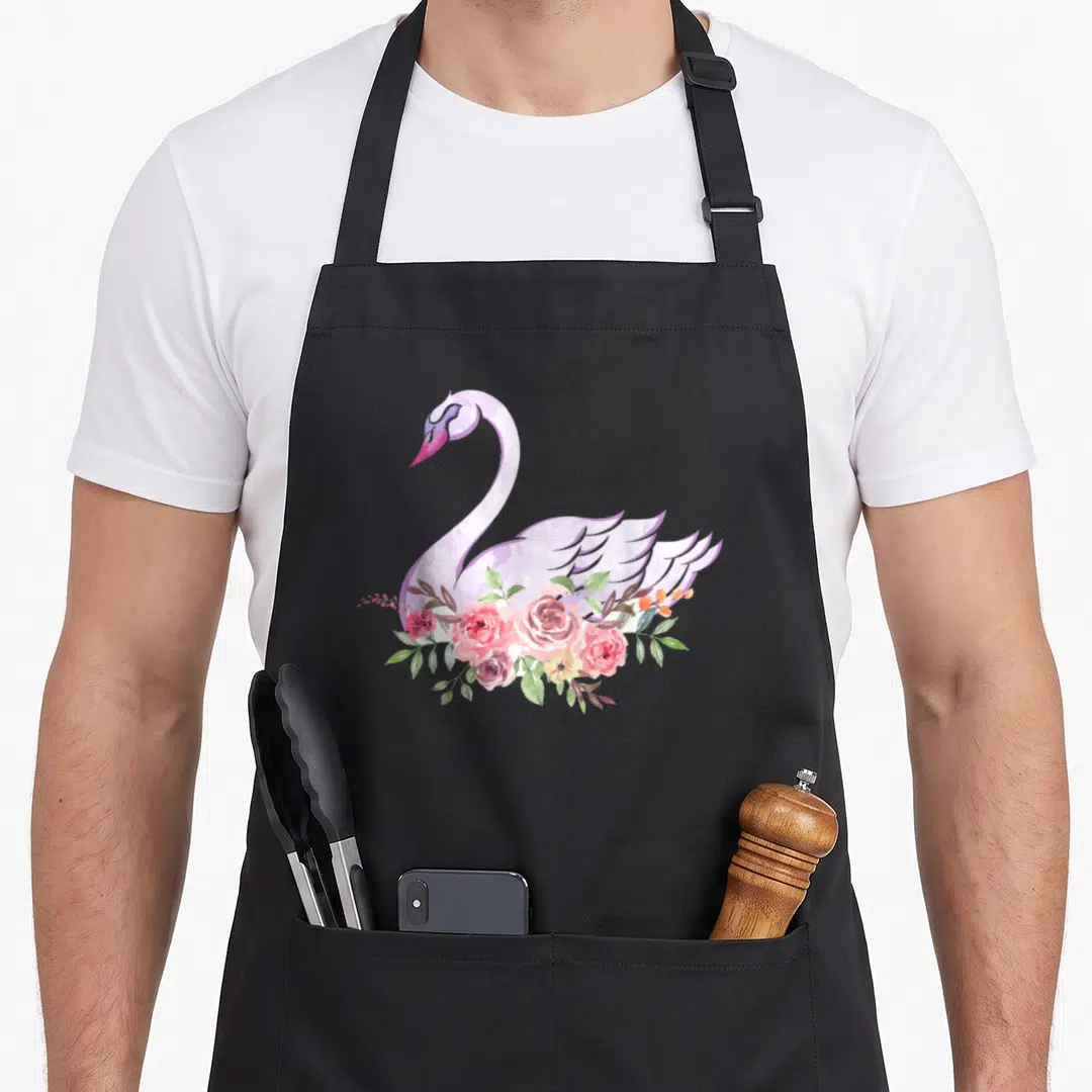 Flower beautiful apron - Watercolor swan in light purple with pink roses and green leaves overlapping its body — shown on a black cotton canvas apron against a white background