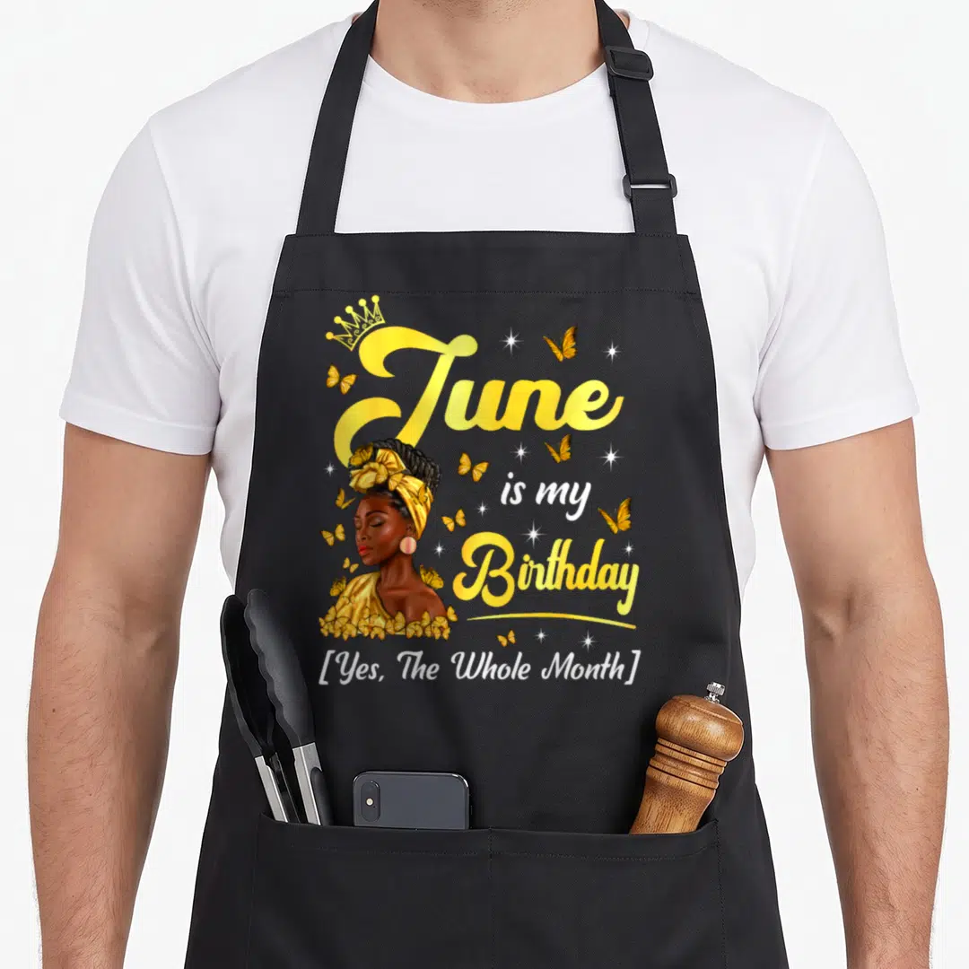 June birthday african american aprons - Cartoon woman with crown and butterflies next to text June is my Birthday Yes — shown on a black cotton canvas apron against a white background