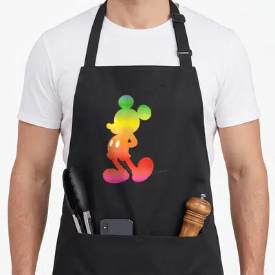 Gradient silhouette rainbow apron - Mickey Mouse silhouette filled with green yellow orange red purple gradient colors — shown on a black cotton canvas apron against a white background