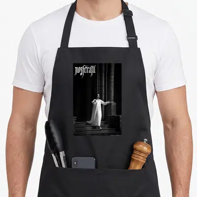 Nosferatu gothic apron - Gothic text above a woman in a white dress standing on stone steps between dark pillars — shown on a black cotton canvas apron against a white background