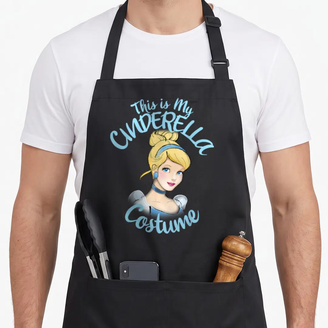 Cinderella halloween white apron - Cartoon Cinderella portrait framed by arched text reading This is My Costume — shown on a black cotton canvas apron against a white background
