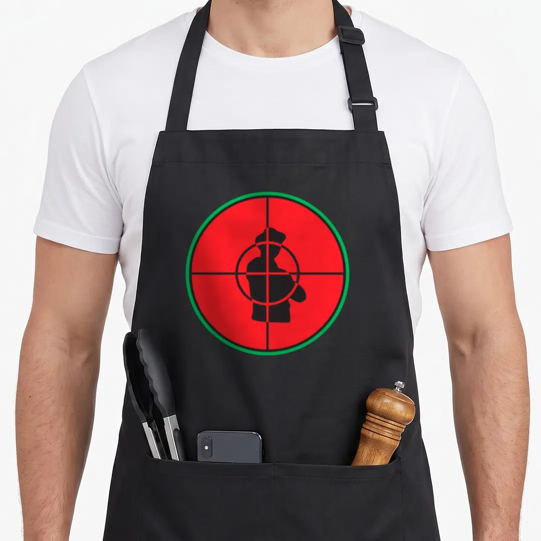 Public big band apron - Red circular crosshair with green border enclosing a black human silhouette in minimalist style — shown on a black cotton canvas apron against a white background