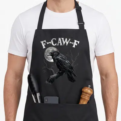 Bird gothic apron - F-CAW-F text above a black crow perched on a branch in front of a moon — shown on a black cotton canvas apron against a white background