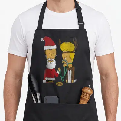 Beavis christmas apron - Beavis in Santa suit and Butt-Head as reindeer with small logo bubble — shown on a black cotton canvas apron against a white background
