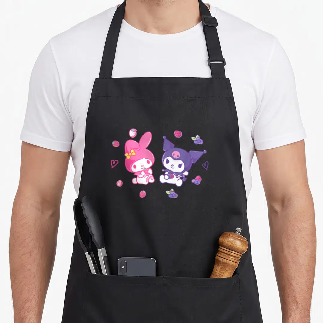 Berry my melody apron - My Melody and Kuromi sitting with pink and purple berries and hearts — shown on a black cotton canvas apron against a white background