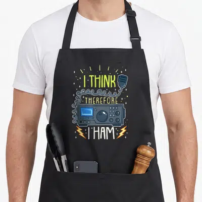 Ham cb radio apron - Cartoon radio with I THINK THEREFORE I HAM text and coiled cable — shown on a black cotton canvas apron against a white background