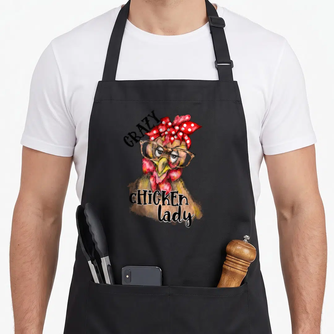 Leopard chicken apron - Cartoon brown chicken wearing glasses and red polka dot bow with text Crazy Chicken lady — shown on a black cotton canvas apron against a white background