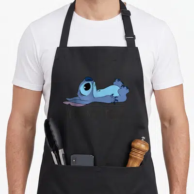 Funny nope not today apron - Blue cartoon creature lying flat above dark grey text reading NOPE NOT TODAY — shown on a black cotton canvas apron against a white background