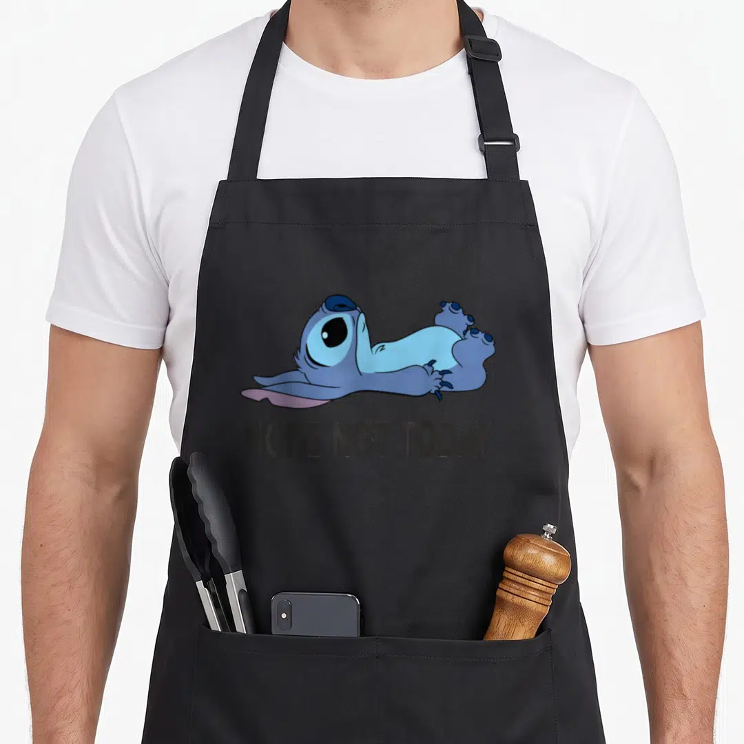 Funny nope not today apron - Blue cartoon creature lying flat above dark grey text reading NOPE NOT TODAY — shown on a black cotton canvas apron against a white background
