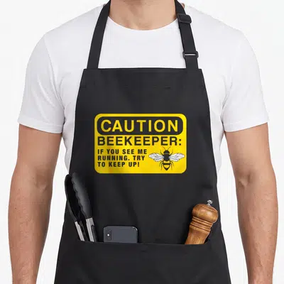 Beekeeping beekeeper apron - Yellow caution sign with bee graphic and text about running — shown on a black cotton canvas apron against a white background