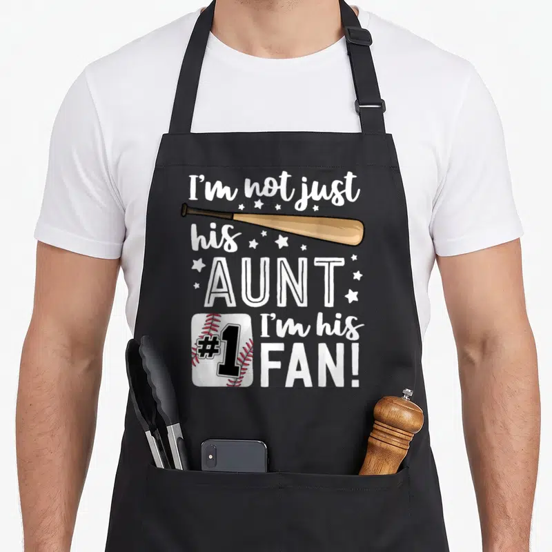 His family aprons - Baseball bat and #1 ball with I'm his AUNT I'm his FAN text and stars — shown on a black cotton canvas apron against a white background