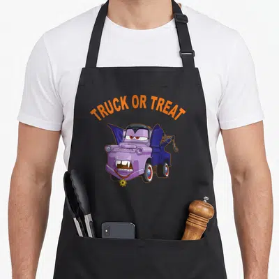 Car halloween apron - Purple tow truck vampire with TRUCK OR TREAT text and yellow flower — shown on a black cotton canvas apron against a white background