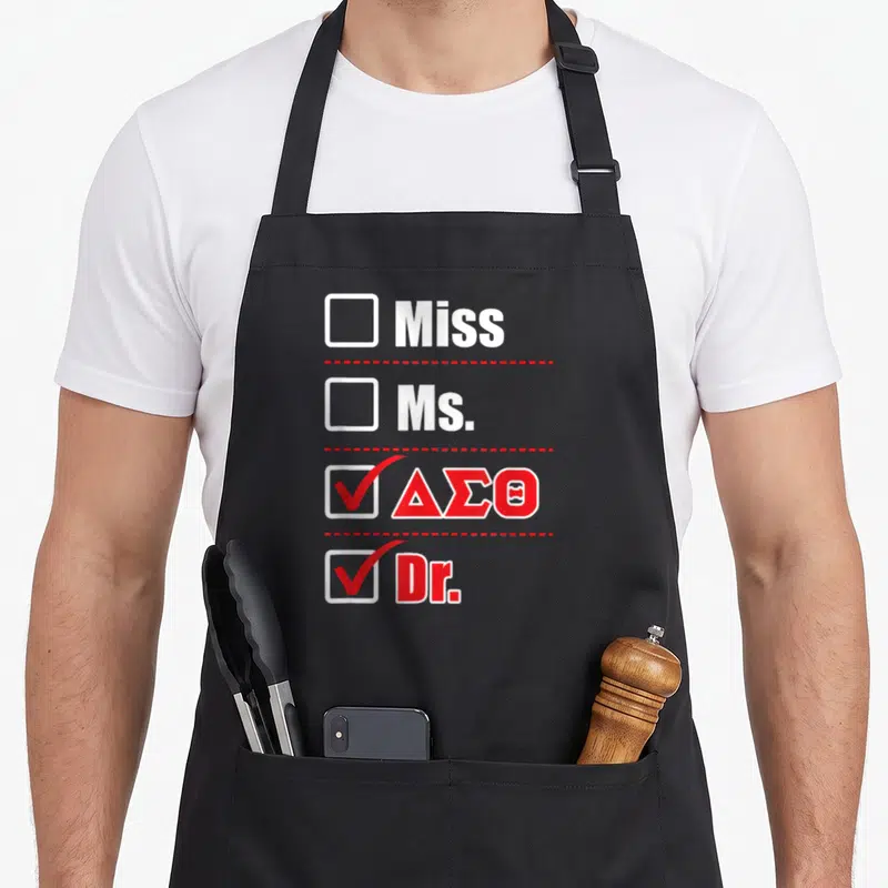 Sigma doctor apron - Checklist with Miss, Ms, Delta Sigma Theta, and Dr checked in red and white — shown on a black cotton canvas apron against a white background