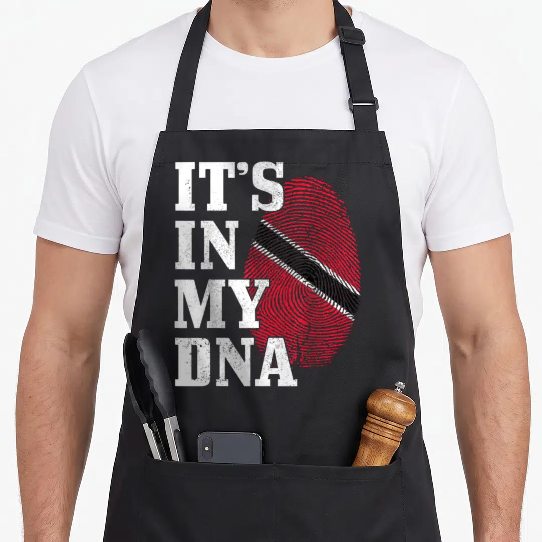 Caribbean trinidad and tobago apron - IT'S IN MY DNA text next to a red fingerprint with a diagonal black and white — shown on a black cotton canvas apron against a white background