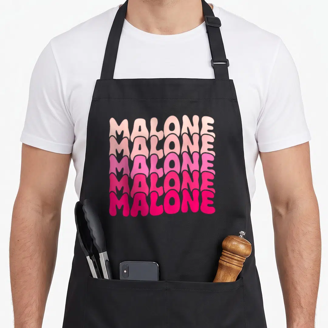 Malone 80s apron - Five stacked lines of Malone text in a pink color gradient — shown on a black cotton canvas apron against a white background