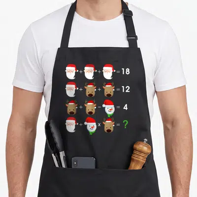 Operation christmas apron - Cartoon Santa reindeer and snowman math equations in white red brown and green — shown on a black cotton canvas apron against a white background