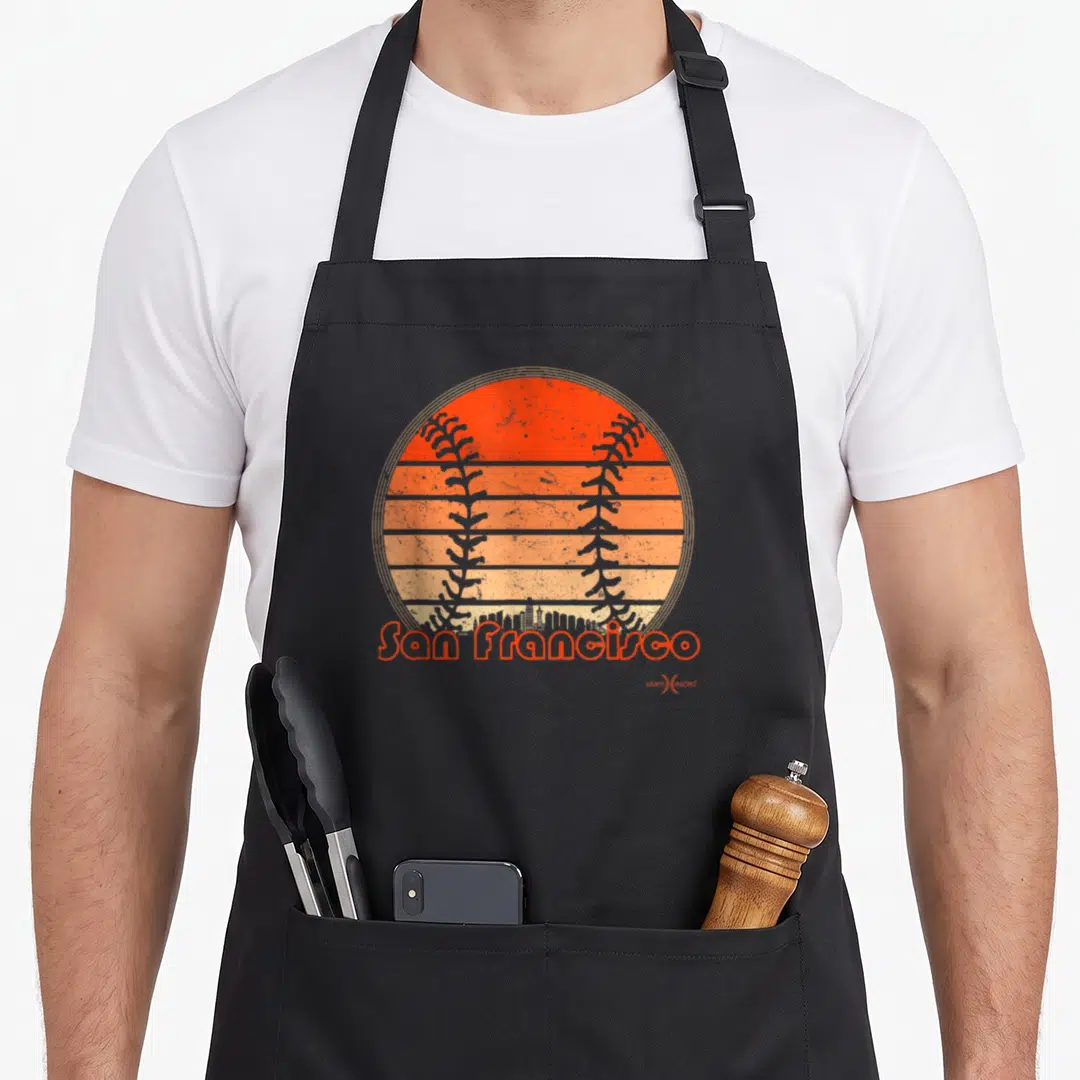 Baseball san francisco apron - Retro orange baseball sunset with SF skyline silhouette and printed text — shown on a black cotton canvas apron against a white background