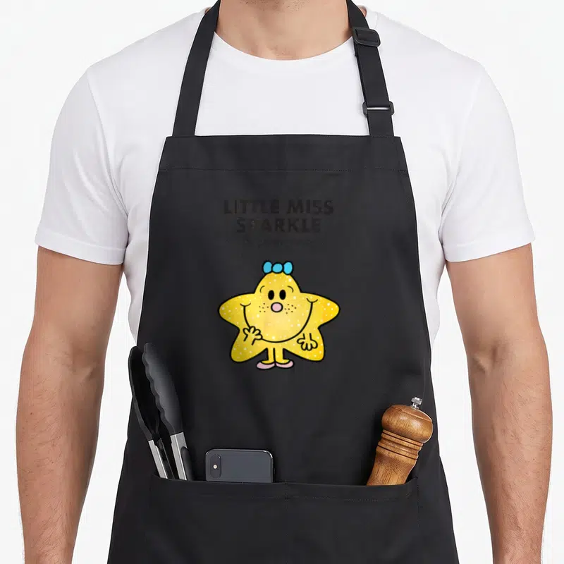 Sparkle mr apron - LITTLE MISS SPARKLE text above yellow star character with blue bow — shown on a black cotton canvas apron against a white background
