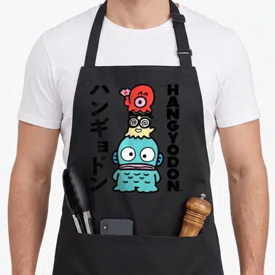 Hangyodon general apron - Blue cartoon fish with red hat, spiral glasses, and flanking black Japanese and English text — shown on a black cotton canvas apron against a white background