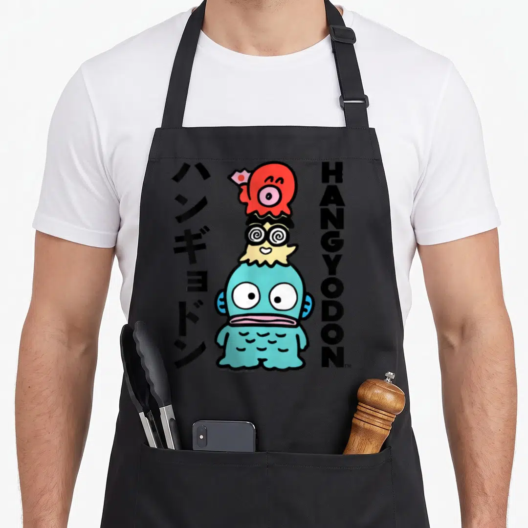 Hangyodon general apron - Blue cartoon fish with red hat, spiral glasses, and flanking black Japanese and English text — shown on a black cotton canvas apron against a white background