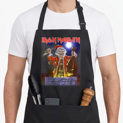 Prayer santa apron - Zombie Santa holding bottle and sack behind stone wall under moon — shown on a black cotton canvas apron against a white background