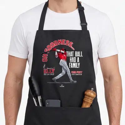 Ball family aprons - Elly De La Cruz swinging bat with OH GOODNESS THAT BALL HAD A FAMILY text in red and white — shown on a black cotton canvas apron against a white background