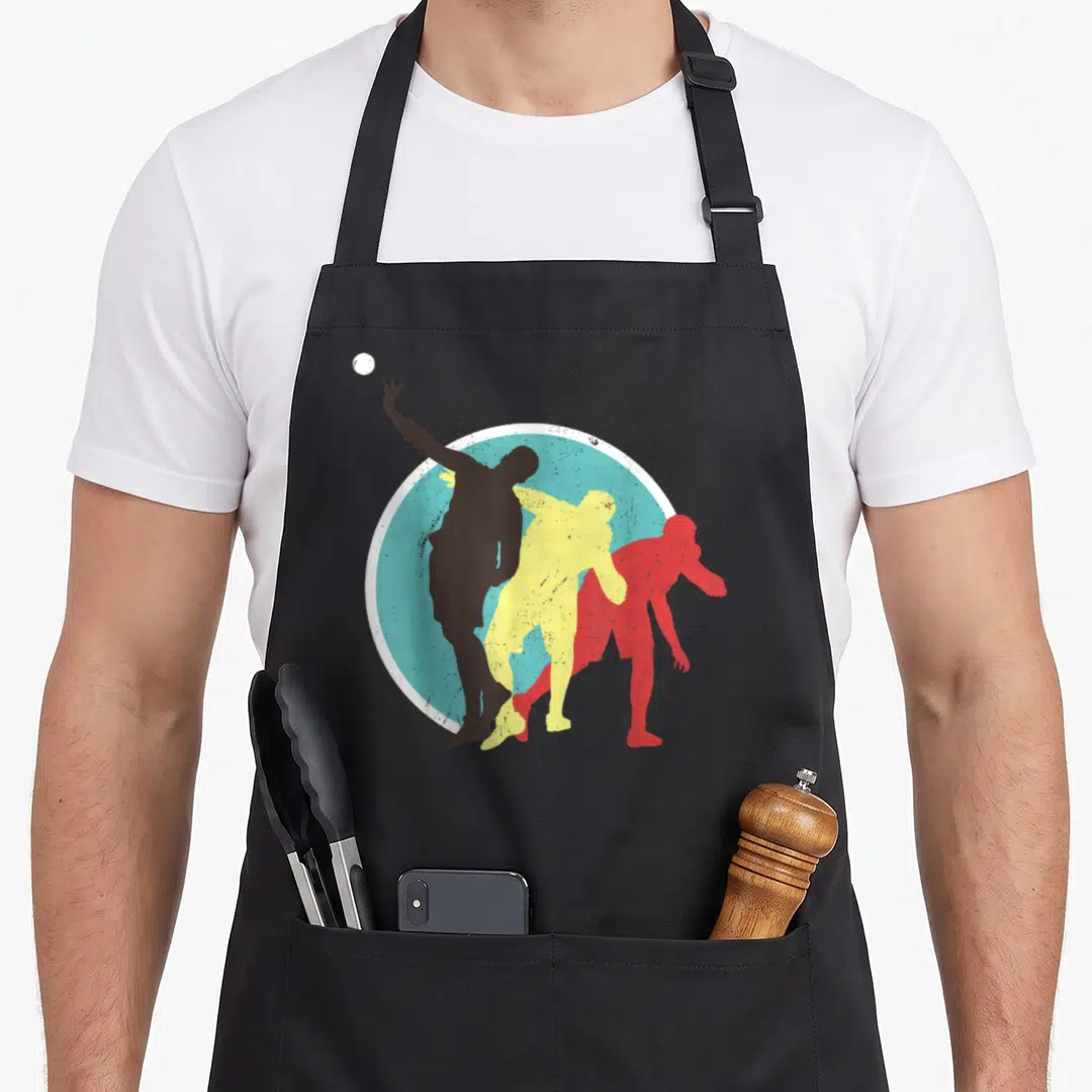 Athlete track apron - Three retro volleyball player silhouettes in brown, yellow, red over light blue circle with white — shown on a black cotton canvas apron against a white background