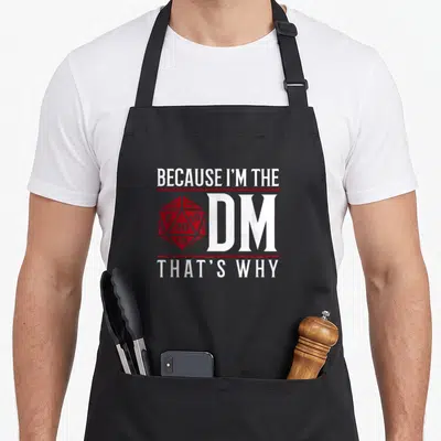 Cool novelty apron for the kitchen - Red 20-sided die beside white stacked text separated by red lines — shown on a black cotton canvas apron against a white background