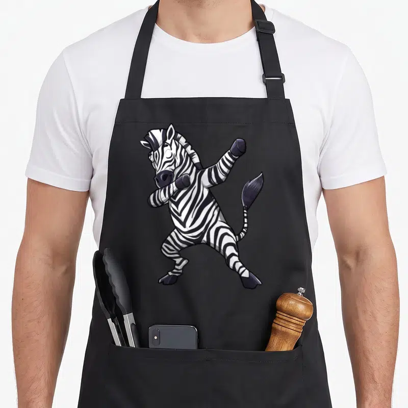 Dabbing african apron - Cartoon zebra in dab pose printed on black bib apron — shown on a black cotton canvas apron against a white background