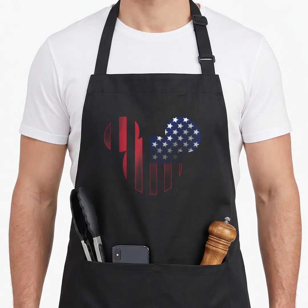 Americana crazy mouse man apron - Mickey Mouse silhouette filled with red white and blue USA flag pattern — shown on a black cotton canvas apron against a white background